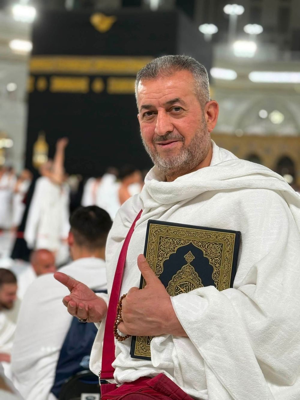 حاج أمام الكعبة المشرفة والقرآن الكريم