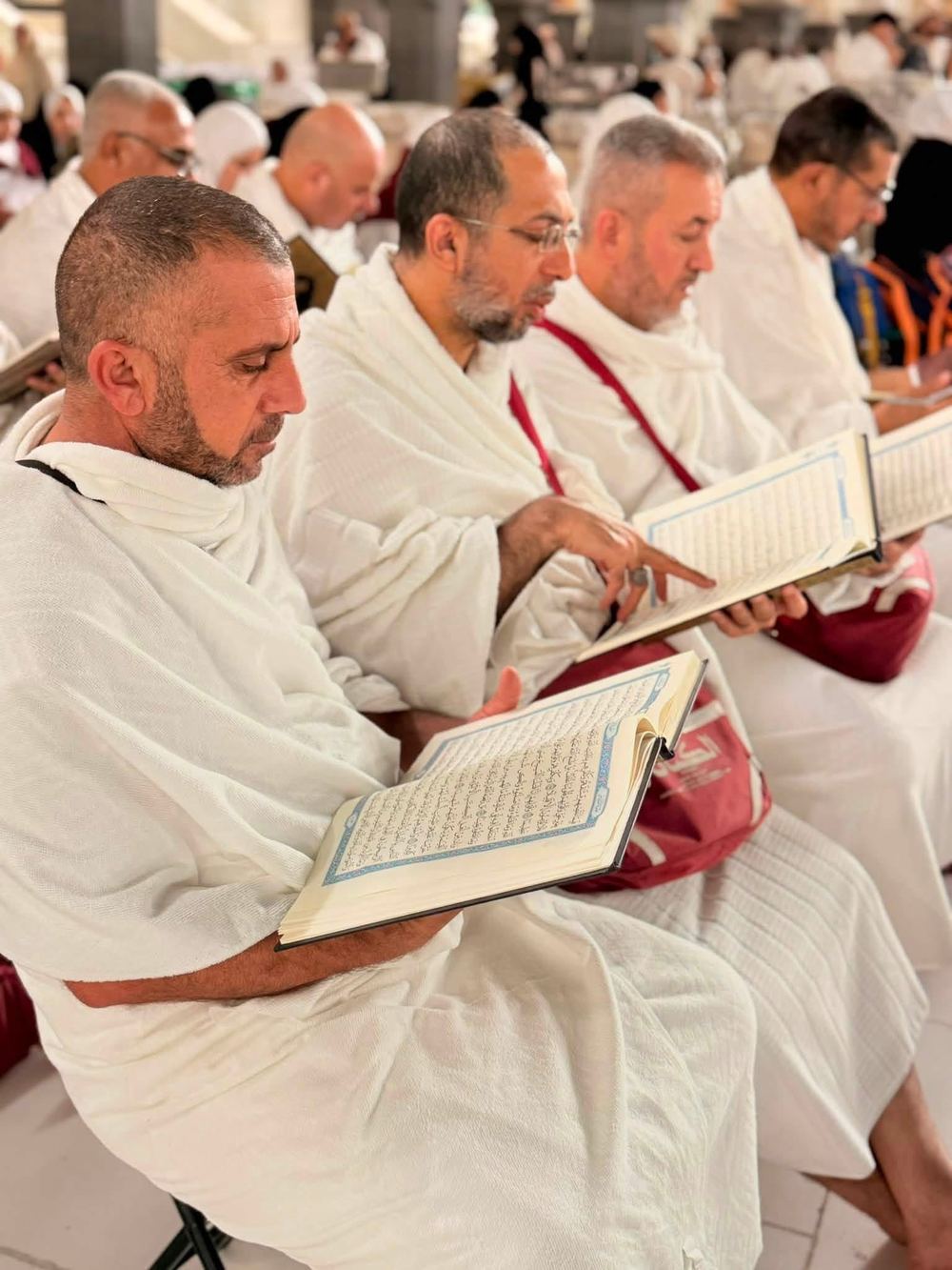 مجموعة حجاج يقرأون القرآن الكريم بالحرم