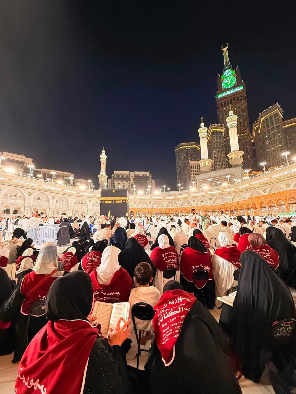 جموع الحجاج أمام الكعبة ليلاً مع برج الساعة